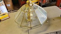 Top view of the hexagonal brass and glass ceiling light fixture showing bulb sockets and glass panels.