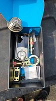 Box containing Kwikset Kevo lock parts including exterior and interior lock units and hardware