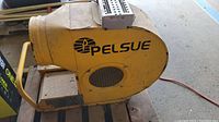 Side view of yellow Pelsue 1500S propane heater showing brand name and ventilation opening.