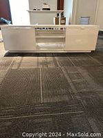 Front view of the white lacquer IKEA TV credenza showing two closed side compartments and a central open shelf with an adjustable middle shelf.