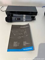 Dual channel receiver at back, two handheld transmitters and instruction manual at front