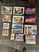 Top-down photo showing all 14 puzzle boxes from various brands and themes including cityscapes, nature, and special collections.
