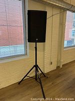 Front view of speaker mounted on stand in a room