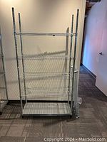 Front view of assembled metal wire shelving unit showing five wire shelves and one solid bottom shelf