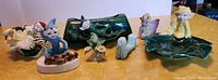 Overview photo of all elf and pixie ceramic figurines and green ceramic planters on a yellow surface