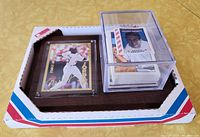 Michael Jordan rookie plaque in original packaging with a stack of baseball cards in a clear case