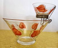 Side view of the chip bowl with dip bowl seated on metal bracket showing orange and gold leaf decoration