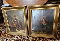 Pair of framed oil paintings on canvas showing historical male figures. Frames are wooden and gold-colored, measuring roughly 24" x 20" each.