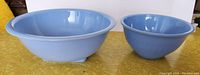 Side-by-side view of two blue glass mixing bowls, larger is Pyrex and the smaller is unmarked but from Jeannette.