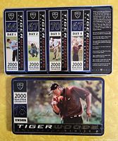 Top view of embossed metal tin featuring four individual golf ball markers with daily scores from the 2000 PGA Championship and Tiger Woods images and signature.
