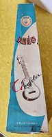 Photo of the ukulele box with blue and white design, Chinese labeling, and illustration of a ukulele
