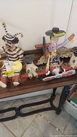 South American wooden decor with airplane and animal riders, Beetlejuice character, and floral decor on table