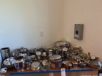 Wide view of entire lot on shelf showing mixed silverplate and pewter pieces