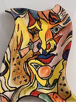 Tray showing close-up detail of colorful abstract face painting.