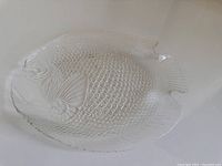 Full view of the clear glass fish-shaped dinner plate showing the overall shape and details
