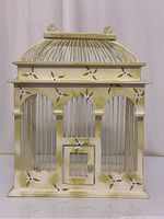 Front view of hand painted decorative bird cage showing floral embellishments, domed top, and small front door.