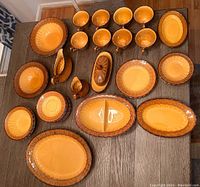 Full set displayed on table showing all 32 pieces including plates, bowls, mugs, platters, gravy boat, butter dish and divided serving plate.