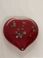 Front view of the red heart-shaped glass with visible embedded millefiori flowers.