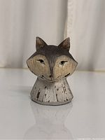 Front view of the small carved wooden fox head sculpture showing facial details and paint wear.