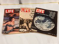 Three LIFE magazines laid side by side showing their diverse covers from 1963, 1968, and 1969.