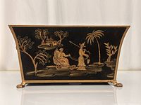 Front view of the rectangular planter box in black with gold hand-painted Asian scenes and lion head feet