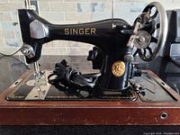 Clear close-up of the sewing machine front and side showing the Singer branding and motor attachment.