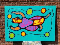 Full view of painting on stretched canvas, turquoise background with stylized multicolor bear design