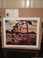 Full view of the lithograph mounted on a brown backing with informational card about Tom Thomson above.
