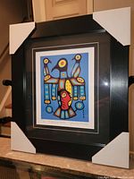 Framed print viewed from the side showing the full frame with protective corners in place.