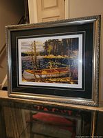 Framed fine art print showing the entire frame and artwork. Displayed on a table with visible reflections in the glass.