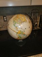 World map globe showing the Americas, mounted on a dark base stand, 17 inches tall by 13 inches wide.