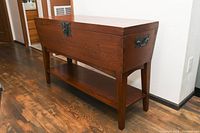 Full-angle view of the closed table showing overall shape, side handle and lower shelf