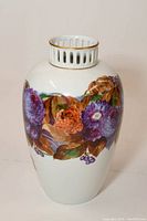 Front view of vase showing colorful floral design and gold trim on openwork neck.