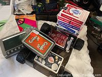 Overall view of vintage cards, games, and electronic device laid on toy vehicle