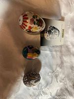 Three collector eggs displayed on white fabric with Satsuma booklet.