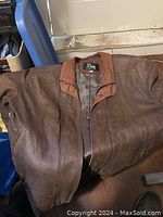 Brown leather jacket by Remy brand, size 38, showing front and collar details.