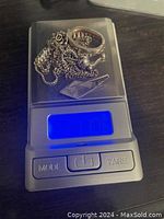 Sterling silver scrap jewelry pieces including chains and rings on a digital scale showing weight of 11.06 grams.