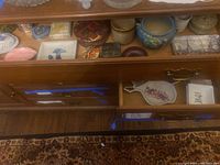 Drawer with various trinket boxes, artisan trivets, small pots, and decorative plates