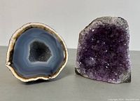 Front view of both geodes showing the amethyst with purple crystals and agate with concentric banding