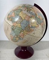 Full view of the globe showing Africa, Europe, and portions of Asia with a maroon stand and meridian.