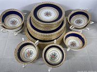 Full set arranged showing stacked plates and bowls with cups surrounding them, illustrating quantity and style