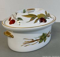 Angle showing oval tureen with lid featuring painted cherries and nuts, gold trim on handles and lid knob.