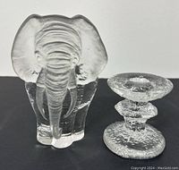 Elephant figurine and one frosted glass candlestick, showing texture and form of both items