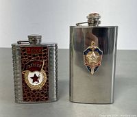 Two Russian stainless steel flasks side by side showing full front detail.