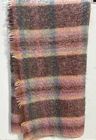 Close-up of the blanket hanging showing the textured mohair fabric and fringe.