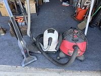 Photo showing all three vacuums together on a garage floor with their hoses visible.