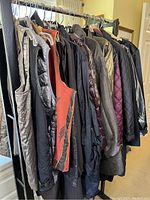 Photo of 11 jackets hanging on a clothing rack showing various styles and colors.