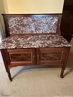 Front view of sideboard showing closed cabinet doors and marble top with backsplash