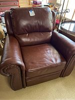 Front view of the dark brown leather recliner chair showing padded seat and backrest
