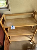 Wooden folding shelf rack showing three shelves, in good condition, light-colored wood.